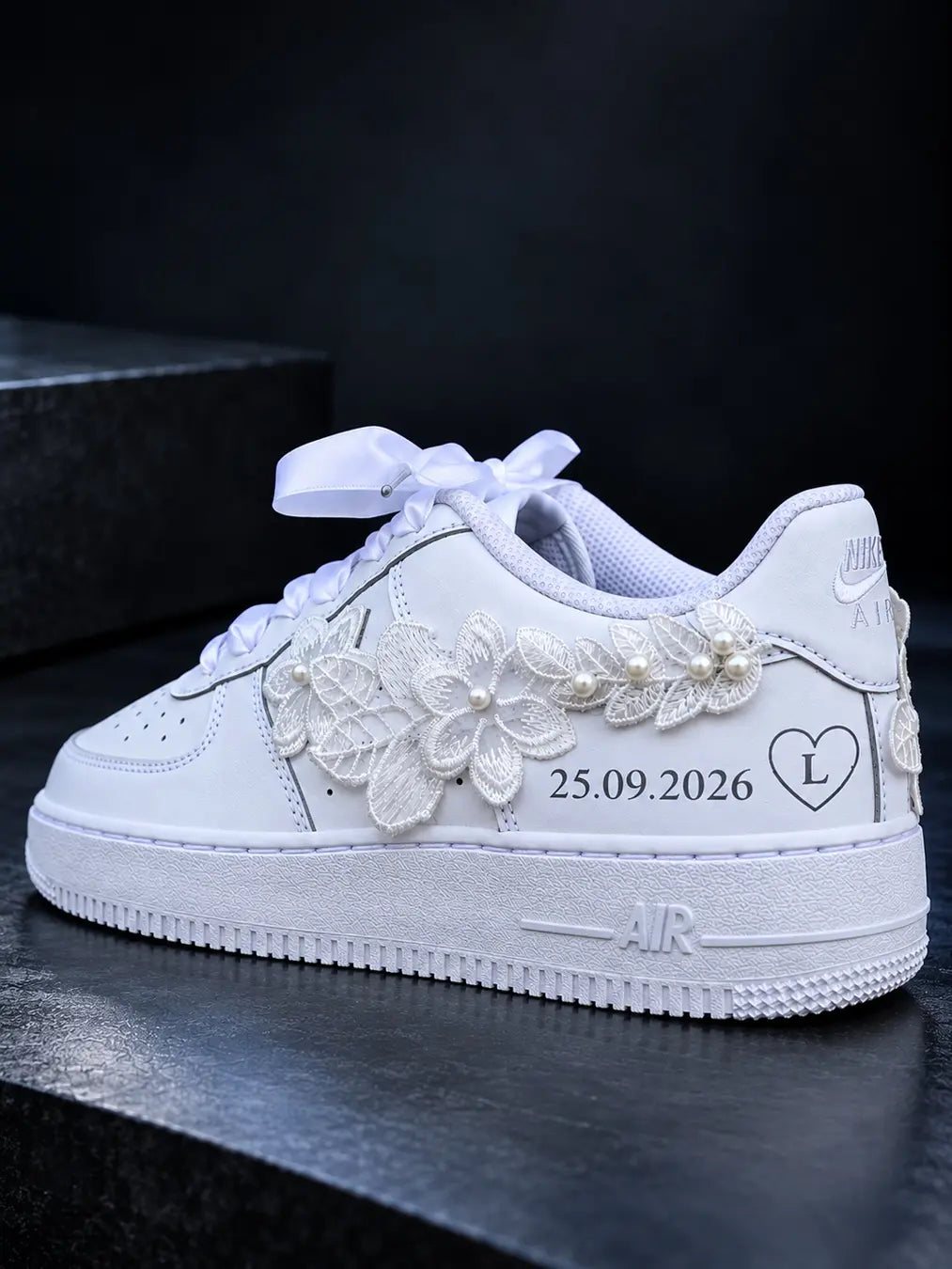 Nike Air Force 1 de mariage blanche ornée de broderies florales et de perles, personnalisée avec une date et une initiale dans un cœur.