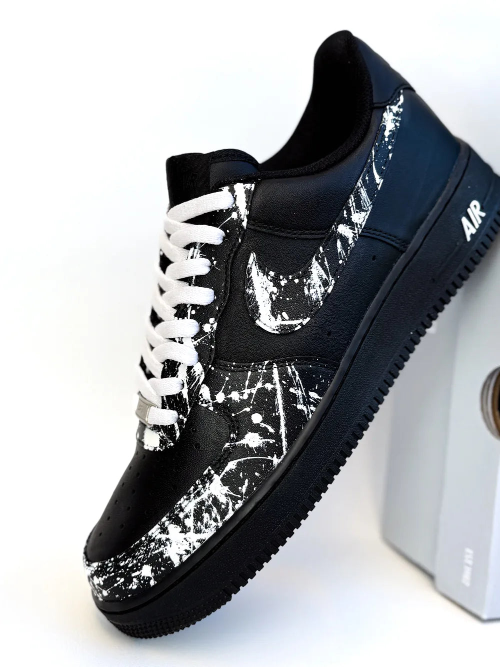 Swoosh Air Force 1 noir avec effet peinture blanche