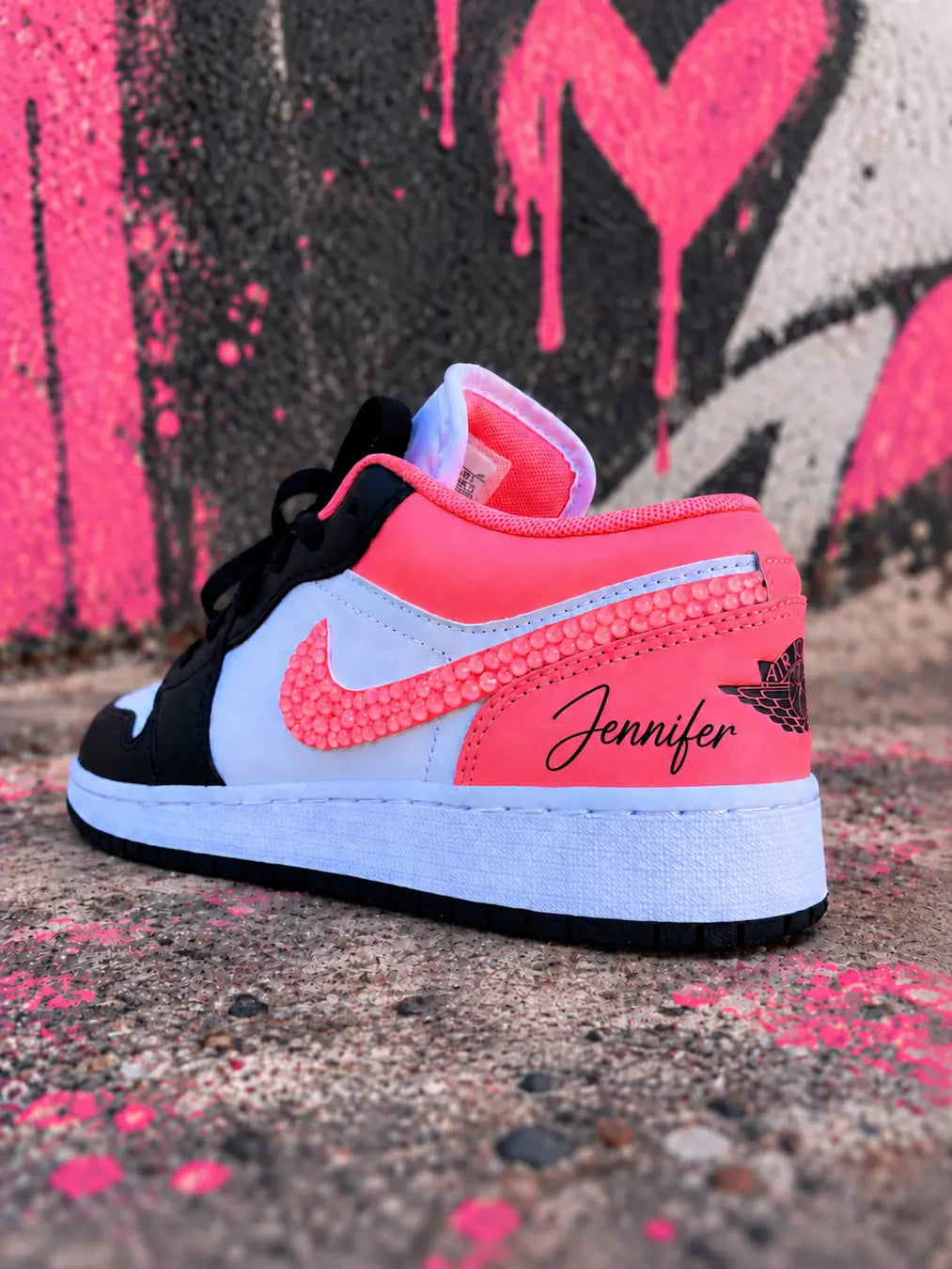 Basket Jordan custom rose corail, noire et blanche pour femme, modèle Air Jordan 1 Low personnalisé au style streetwear