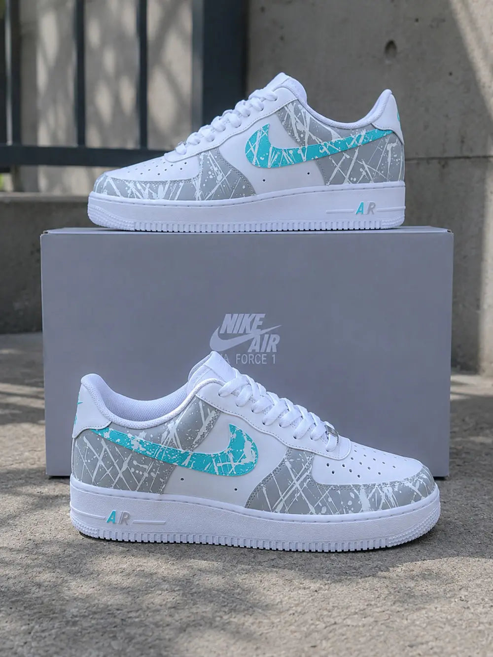 Basket Air Force 1 gris et bleu turquoise personnalisée présentée avec boîte d’origine, sneakers premium artisanales.