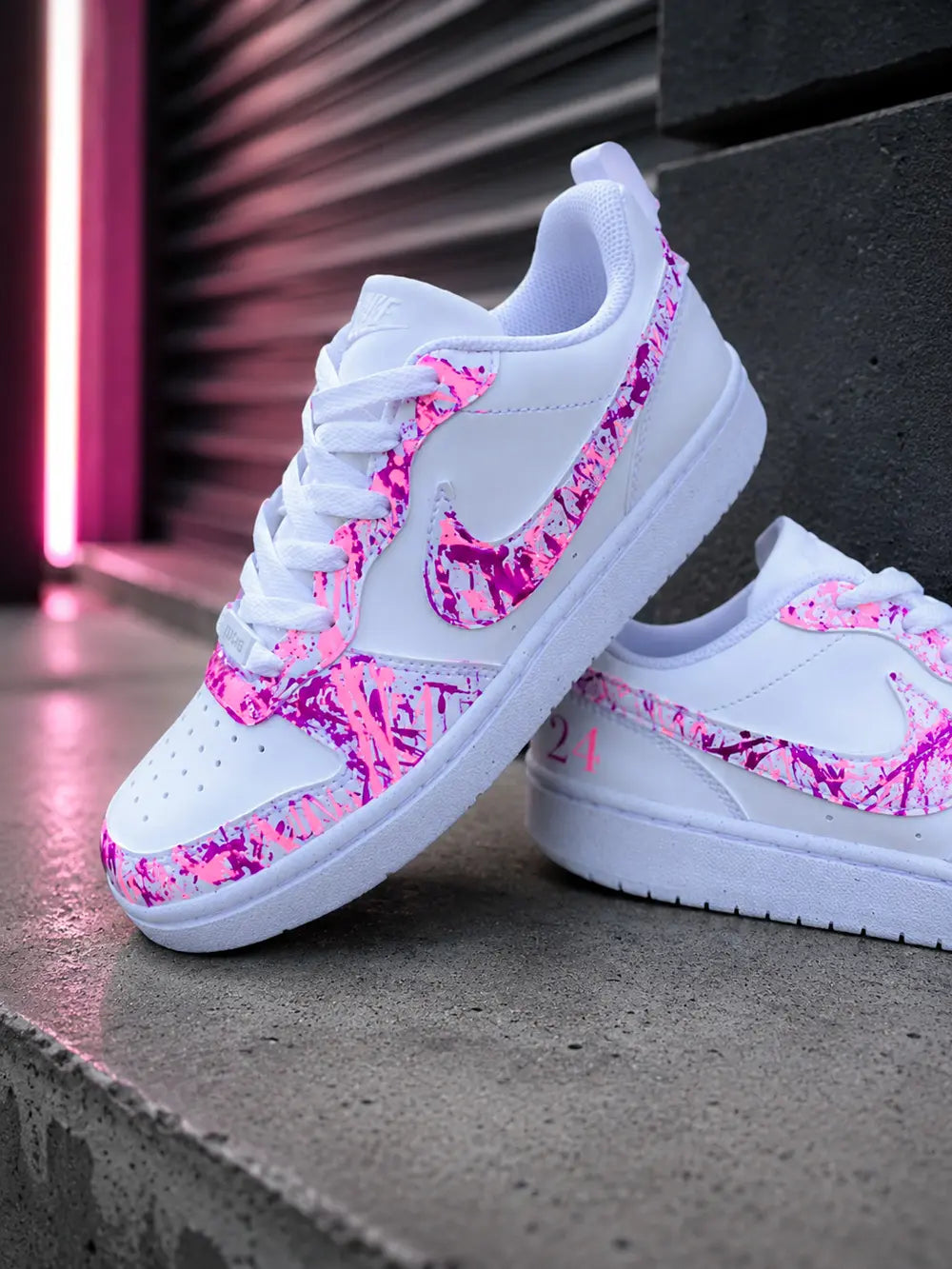 Détail basket custom femme rose fuchsia avec swoosh personnalisé style peinture splash rose et violet sur sneakers Nike blanches.