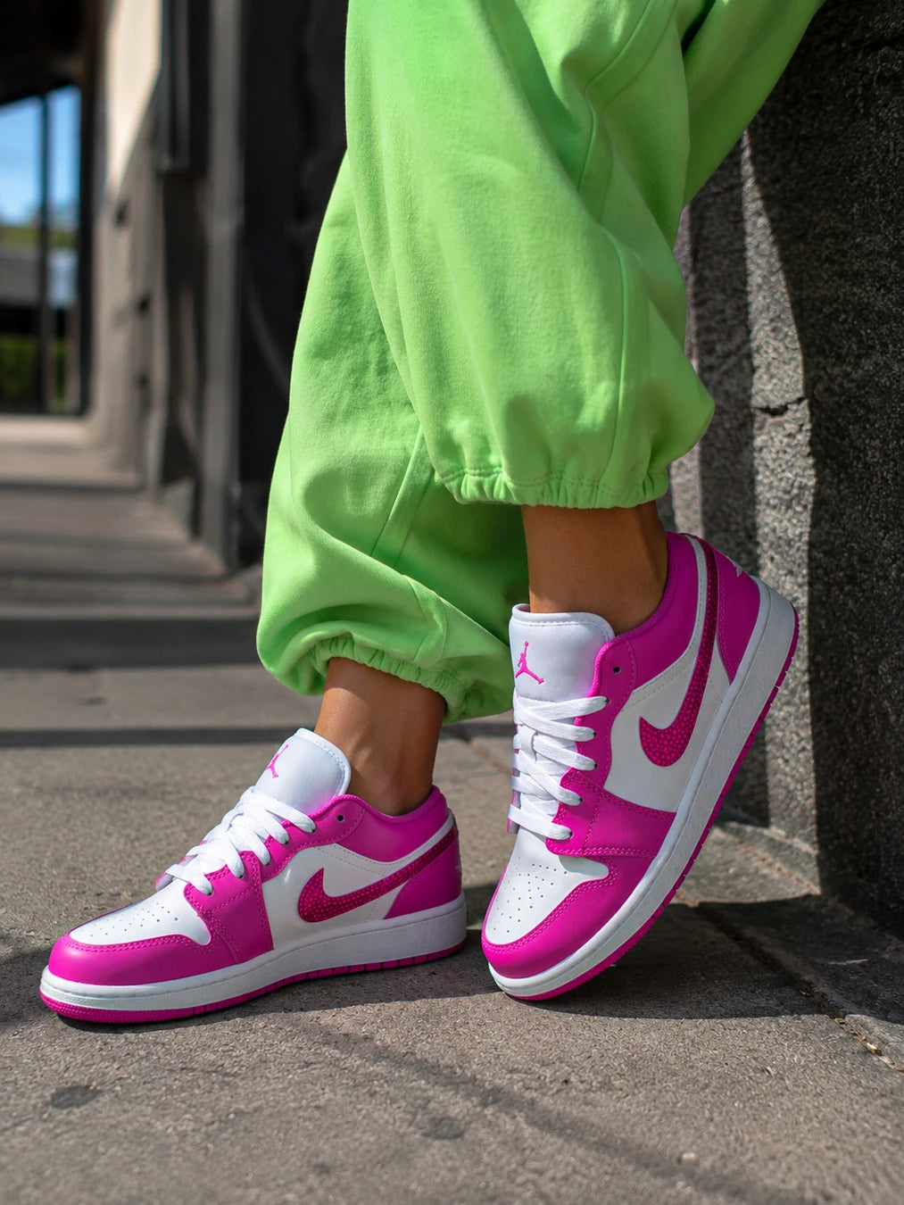 Basket femme Air Jordan personnalisée rose fuchsia portée avec une tenue streetwear.