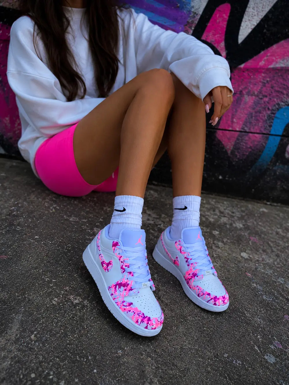 Air Jordan Low personnalisée femme avec design graffiti rose et fuchsia fluorescent, sneakers custom haut de gamme style urbain.