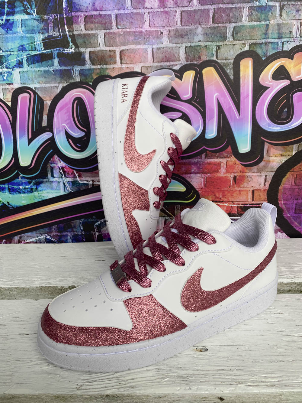 Sur la photo, une paire de baskets Nike rose avec une finition glitter pour un effet scintillant et tendance.