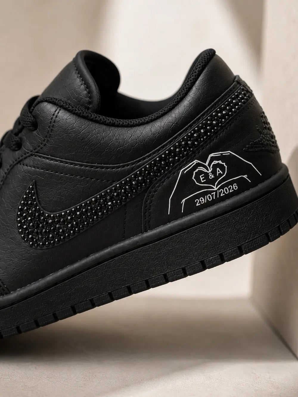 Détail personnalisé sur Air Jordan Low noire avec initiales et date de mariage, basket custom élégante pour cérémonie haut de gamme.
