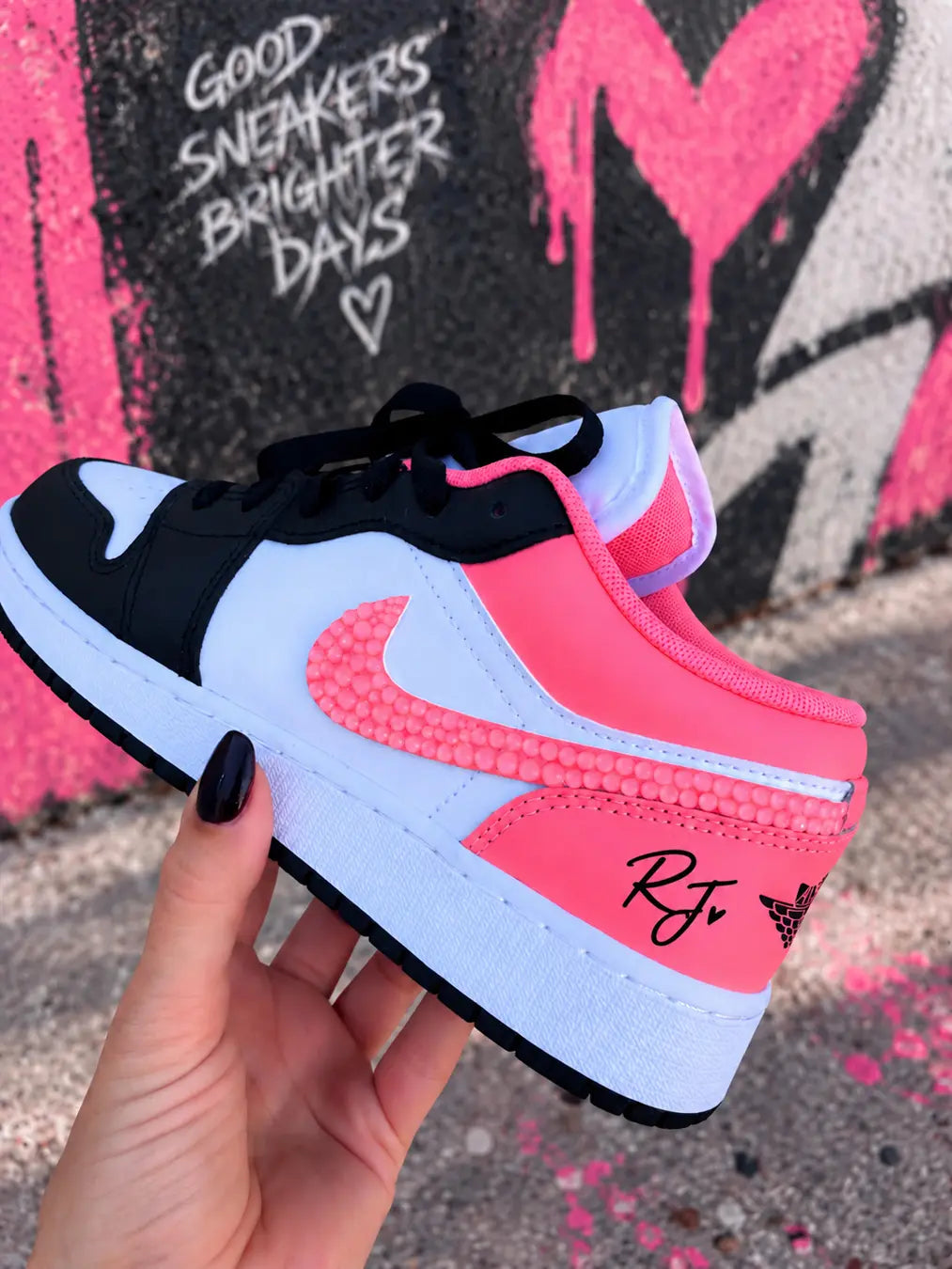Sneakers Jordan custom rose corail pour femme, Air Jordan Low noir et blanc avec détails rose fluo et Swoosh personnalisé