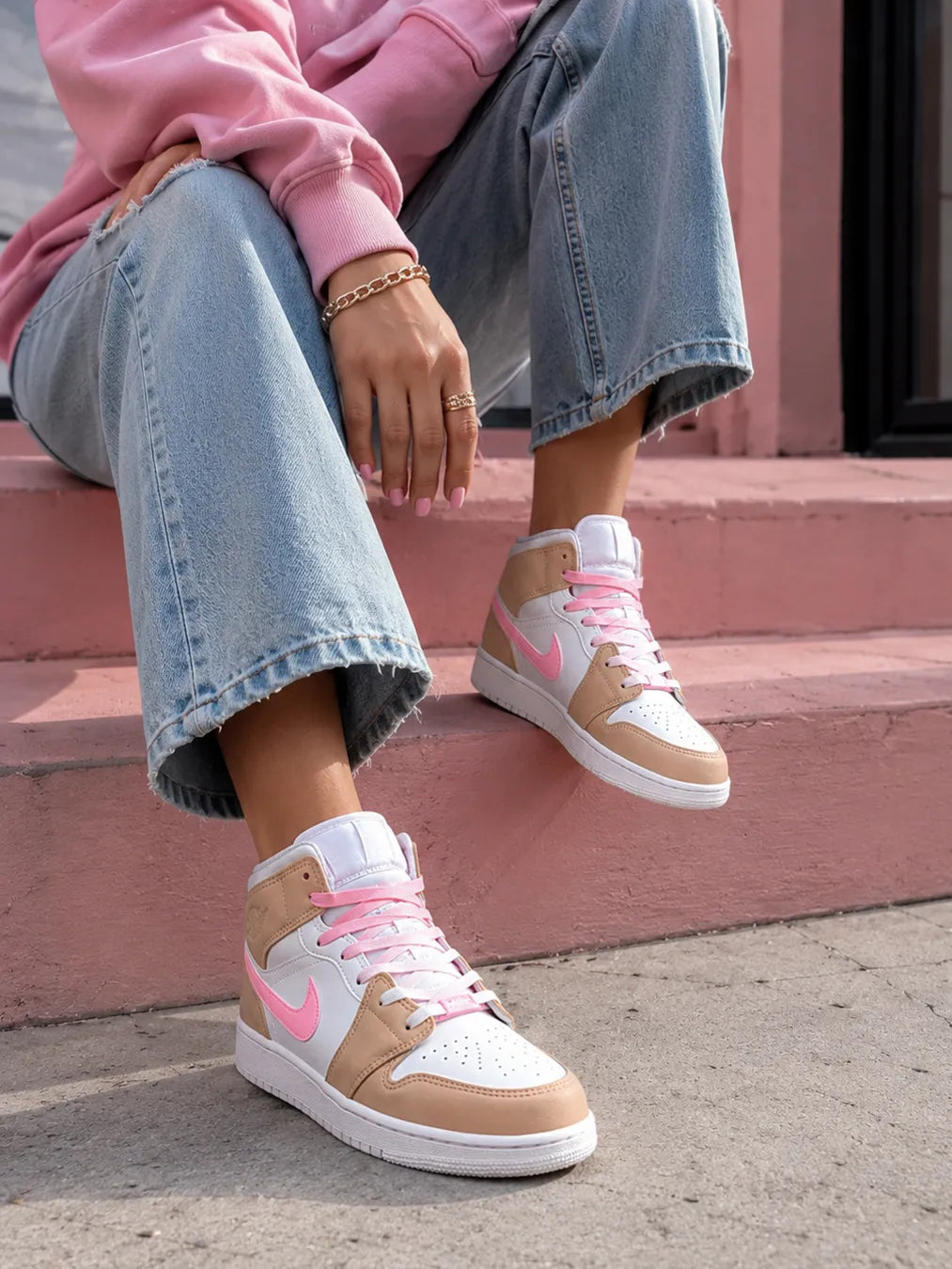 Jordan Mid rose et beige portée avec un look streetwear féminin moderne.