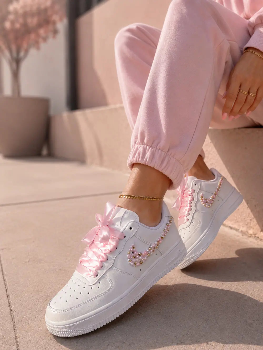 Nike custom femme avec perles roses et détails satin dans une ambiance lifestyle urbaine chic et féminine