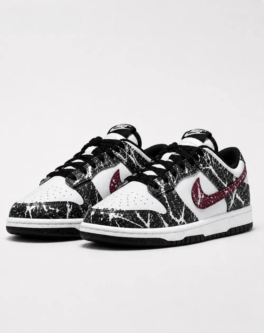 Basket Nike Dunk Low personnalisée noir blanc et bordeaux au style streetwear chic avec design artistique inspiré du dripping peinture.