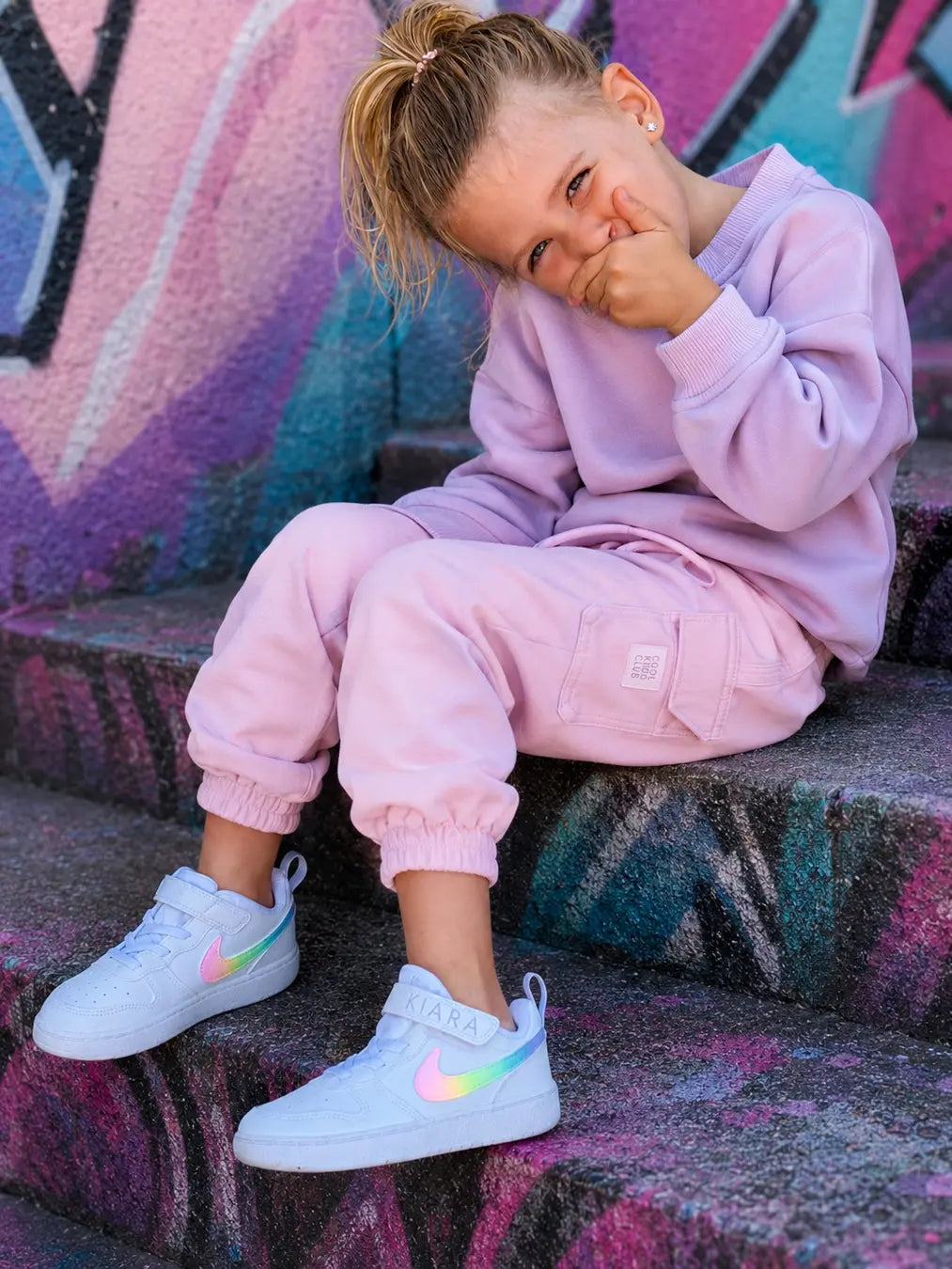 Basket personnalisée Nike pastel pour fille portée avec une tenue streetwear enfant moderne et tendance.