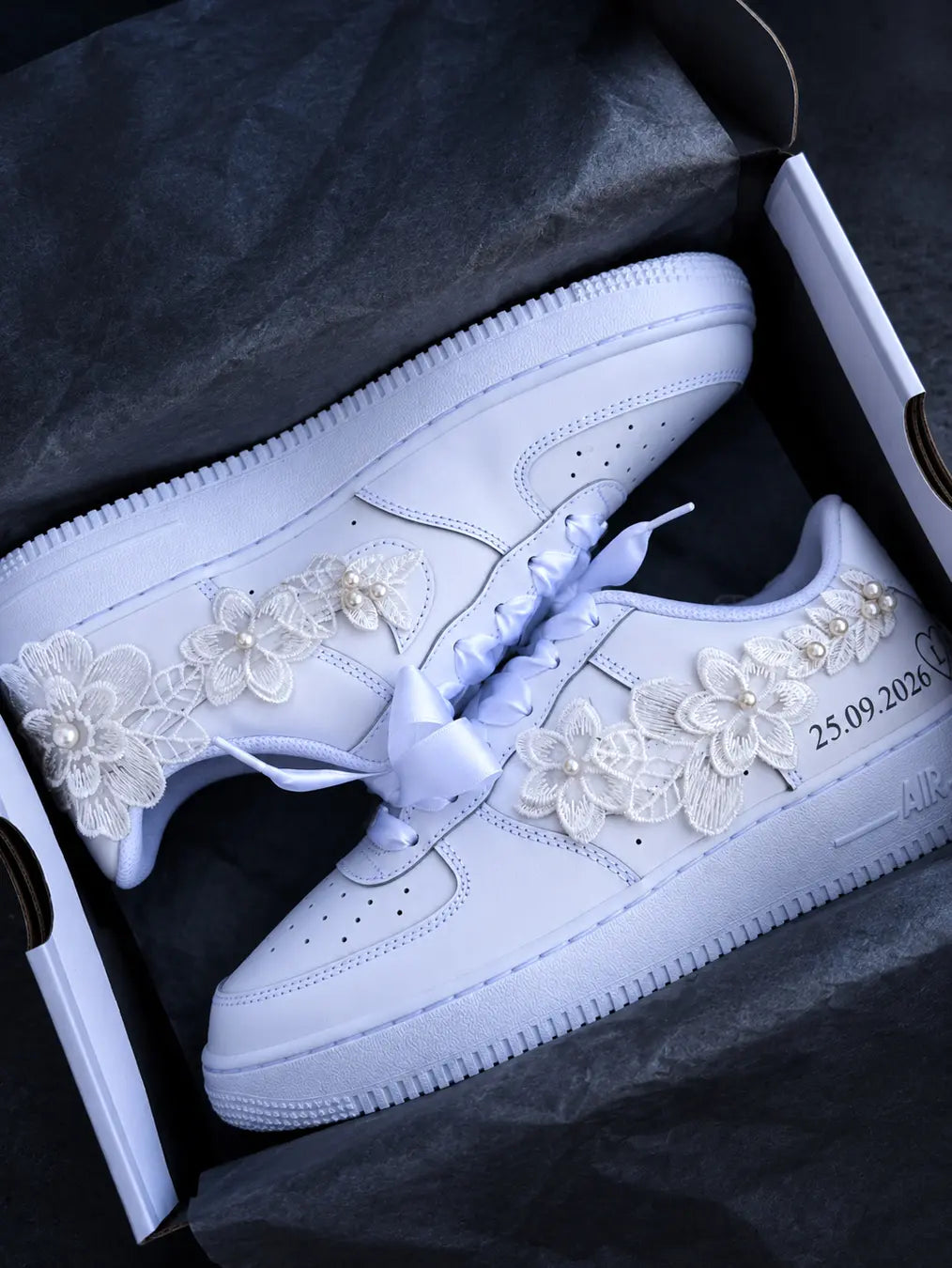 Paire de baskets Nike Air Force 1 custom pour mariée, avec broderies florales, perles, lacets blancs en satin et date personnalisée.