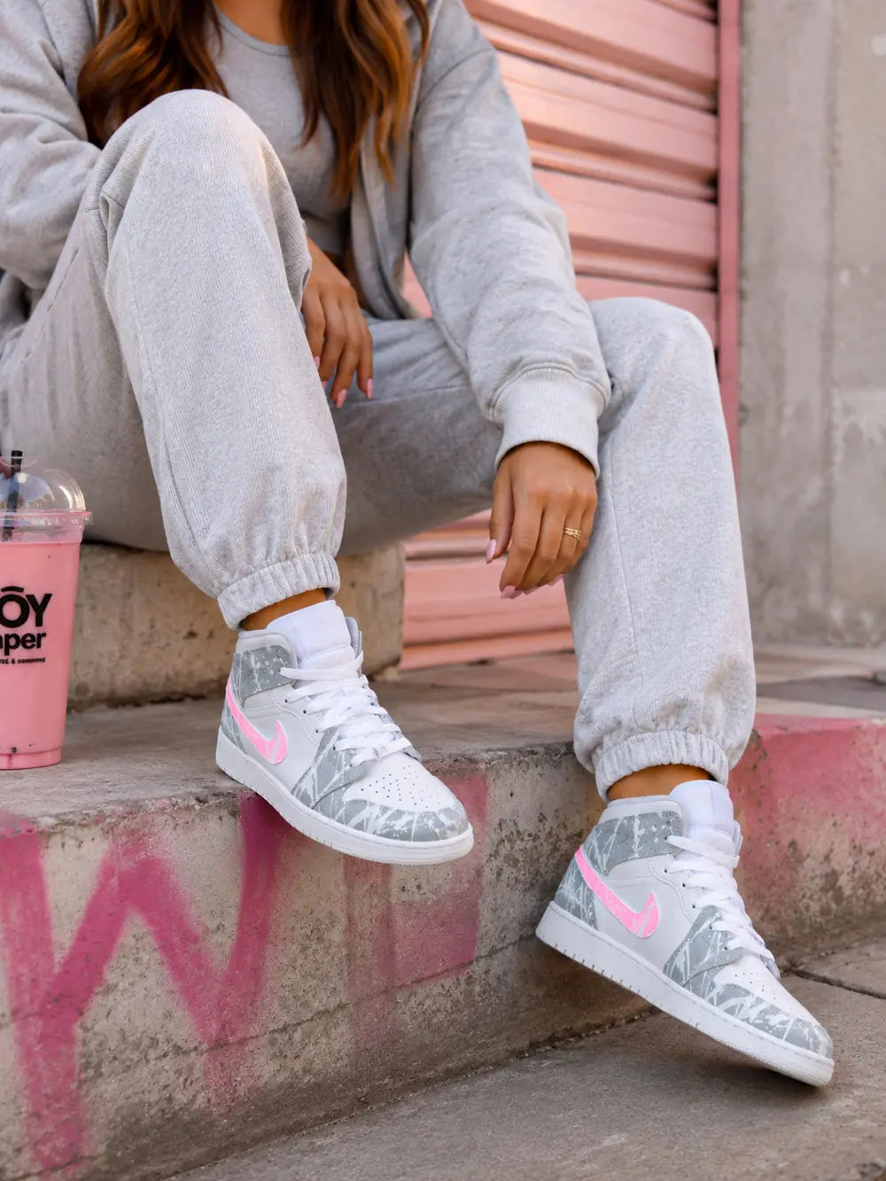 Sneakers Air Jordan mid personnalisées rose fluo et gris effet graffiti pour femme, inspiration streetwear moderne et tendance.