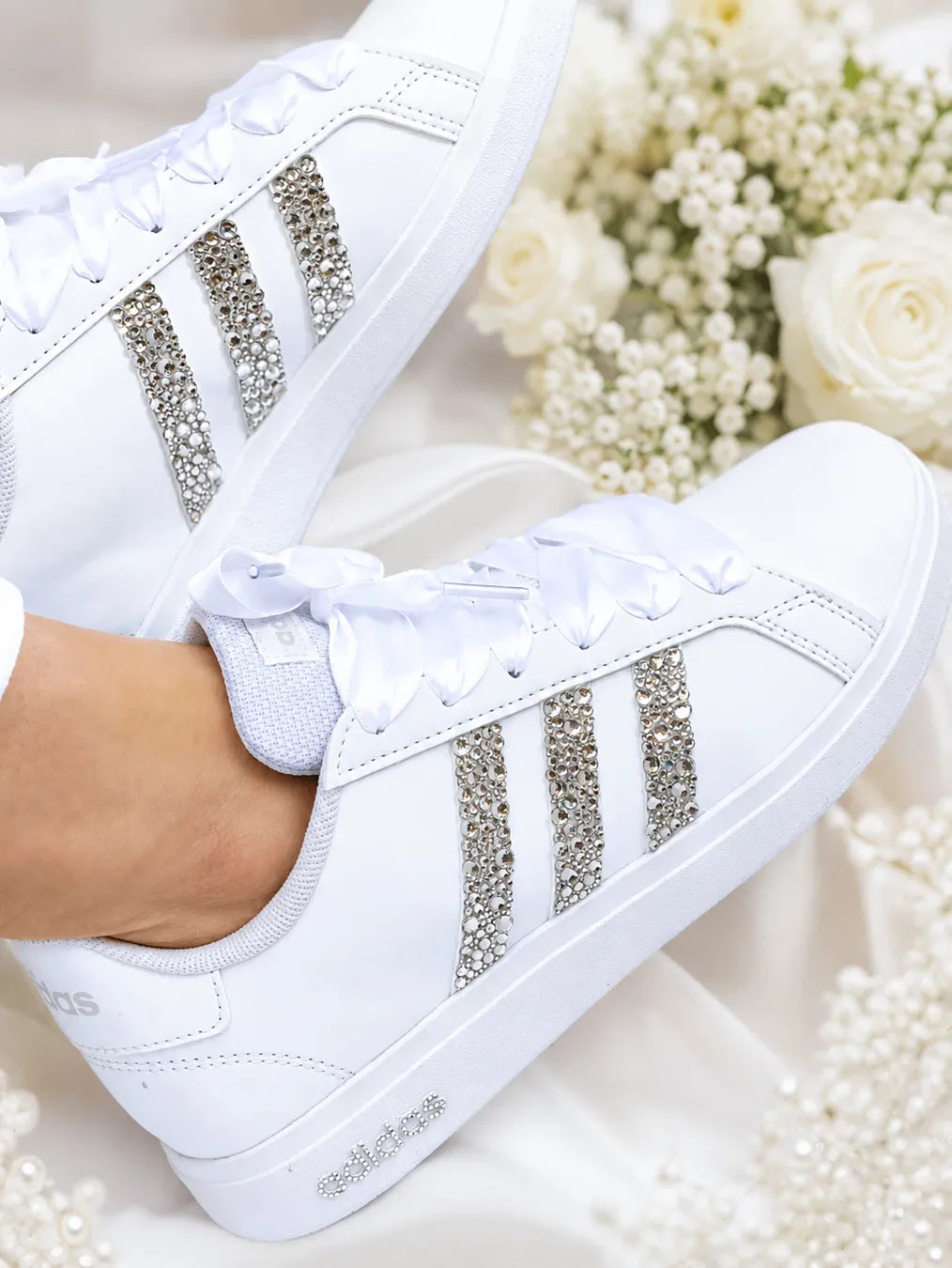 Adidas Grand Court personnalisée mariage avec strass argentés et lacets satin blanc portée par une mariée.