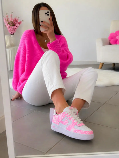Nike Air Force 1 custom rose fluo portée avec tenue blanche et pull rose, sneakers femme tendance au style lifestyle premium.