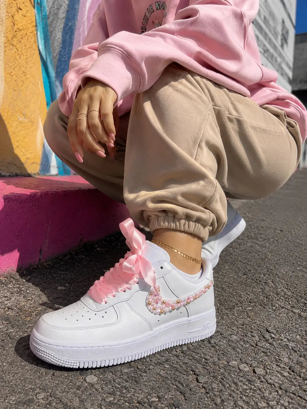 Air Force 1 personnalisée femme portée avec jogging rose pastel et lacets satin rose dans un look streetwear premium