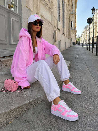 Nike Air Force 1 rose néon personnalisée avec tenue femme rose streetwear, sneakers custom blanches et rose fluo artisanales.