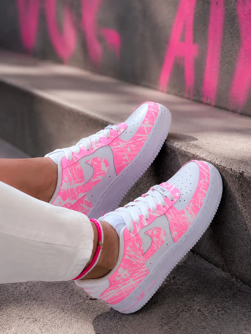 Air Force 1 rose néon portée femme avec design splash rose fluo et style streetwear moderne, sneakers personnalisées haut de gamme.