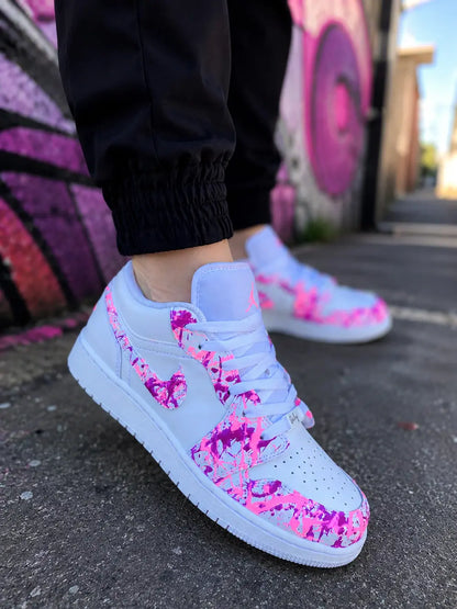 Air Jordan 1 Low custom femme rose fuchsia fluorescente portée en look streetwear urbain, basket personnalisée premium blanche et rose fluo.