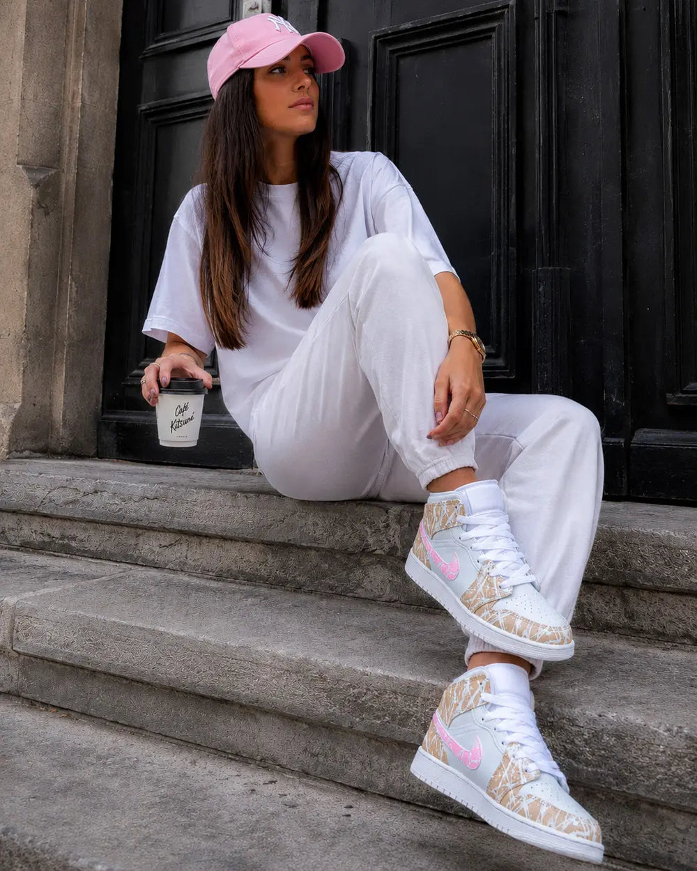 Air Jordan Mid personnalisée femme beige et rose avec effet splash blanc portée en tenue streetwear rose et blanche
