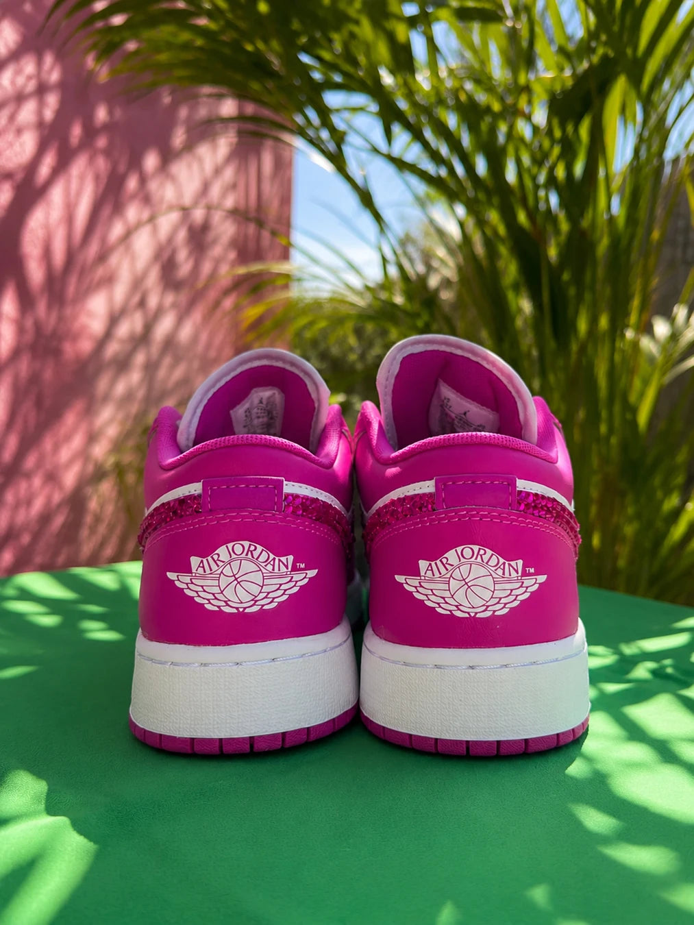Vue arrière d'une paire d'Air Jordan personnalisées rose fuchsia avec finition soignée.