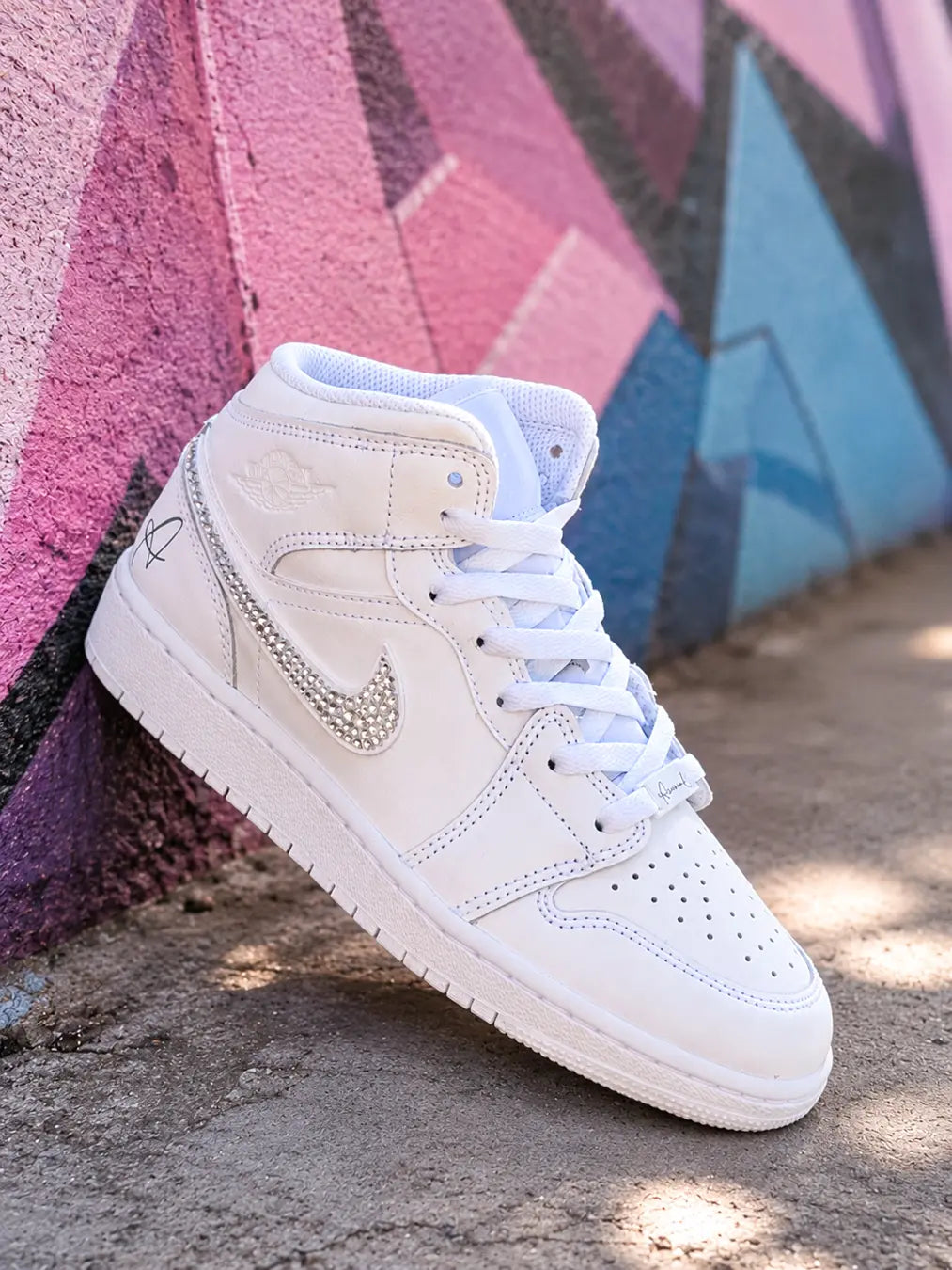 Air Jordan Mid blanche avec bijoux de lacets personnalisés gravés aux prénoms Karin et Théo.