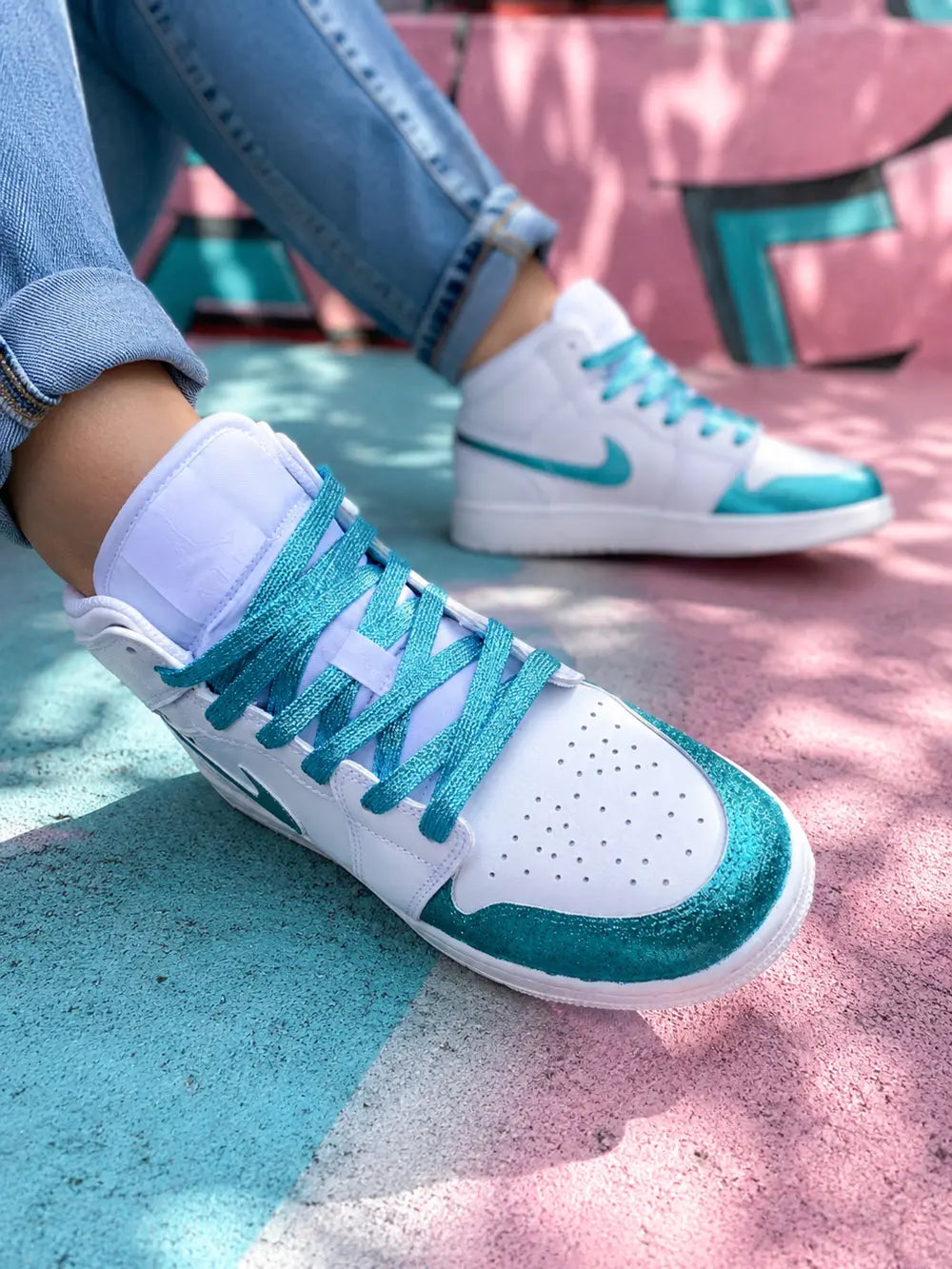 Basket femme Air Jordan 1 Mid blanche et turquoise glitter portée en look urbain casual premium