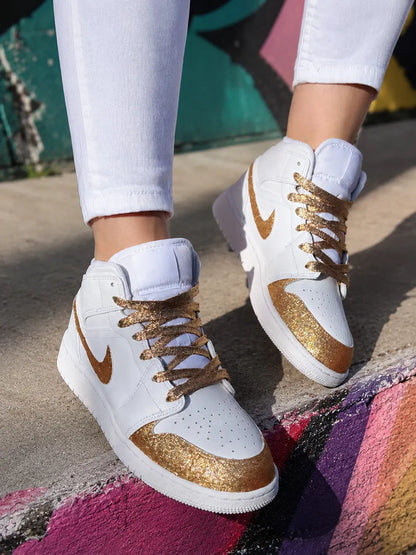 Basket Air Jordan femme blanche et glitter gold photographiée dans une ambiance urbaine premium et lumineuse