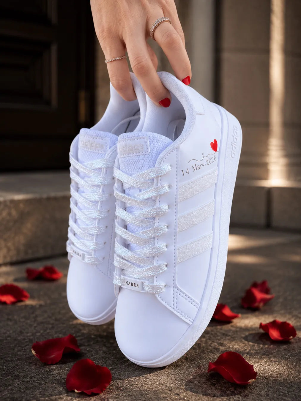 Paire de baskets Adidas personnalisées pour mariage avec lacets pailletés et détails blancs scintillants.