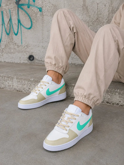 Gros plan des baskets Nike femme beige et turquoise personnalisées, peintes à la main dans notre atelier en France.