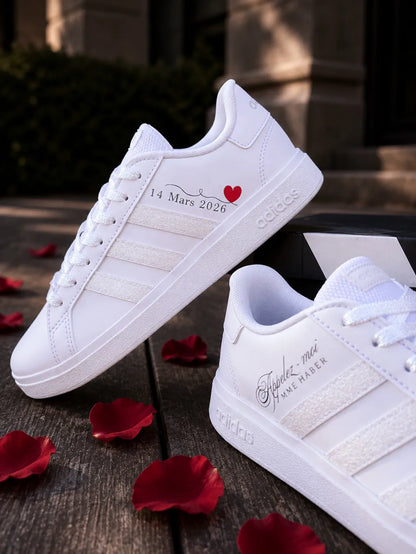 Chaussures de mariée personnalisées Adidas blanches portées avec une robe de mariage.