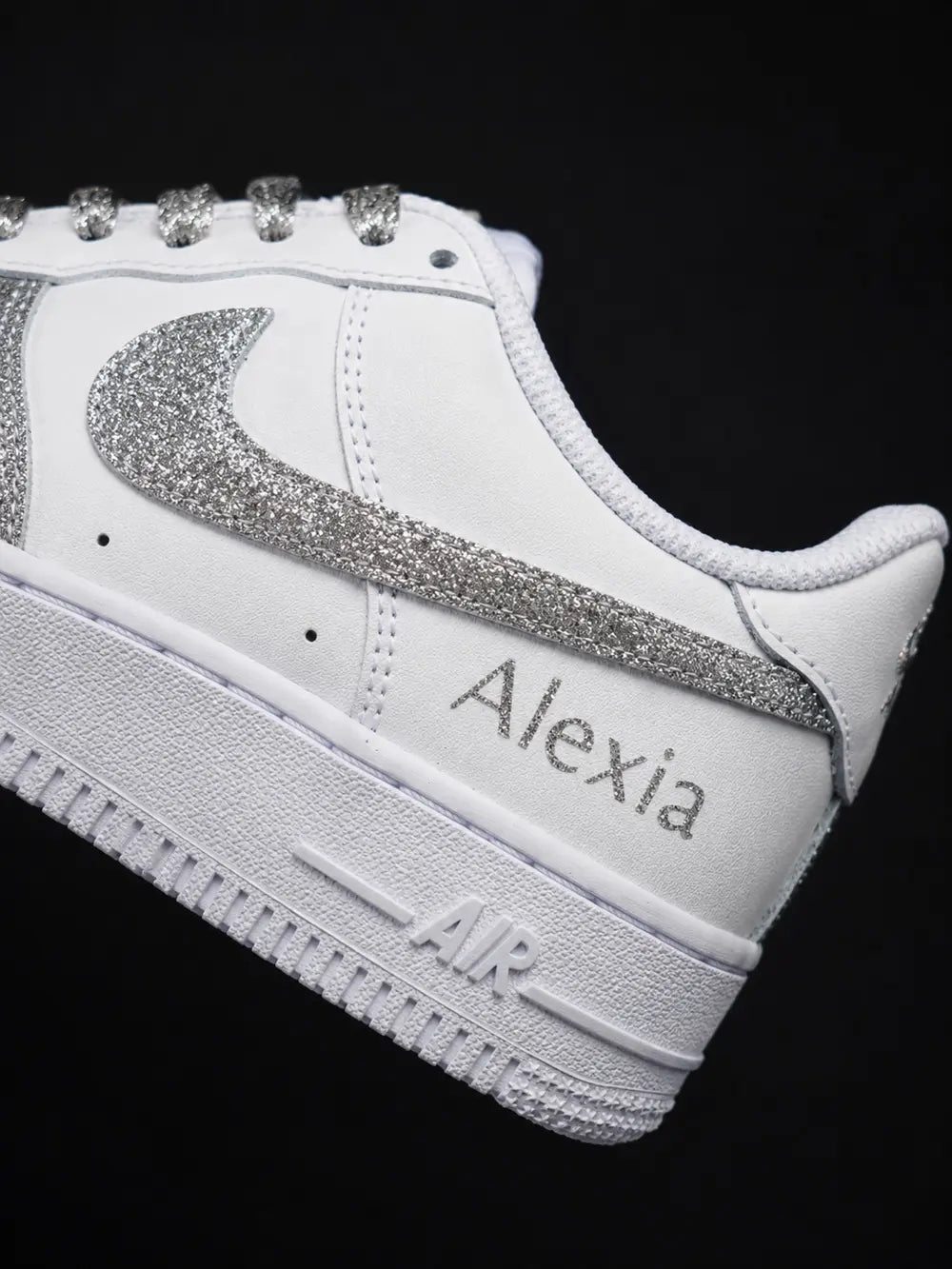 Détail du swoosh glitter argent sur une Nike Air Force 1 personnalisée blanche avec finition pailletée artisanale haut de gamme.