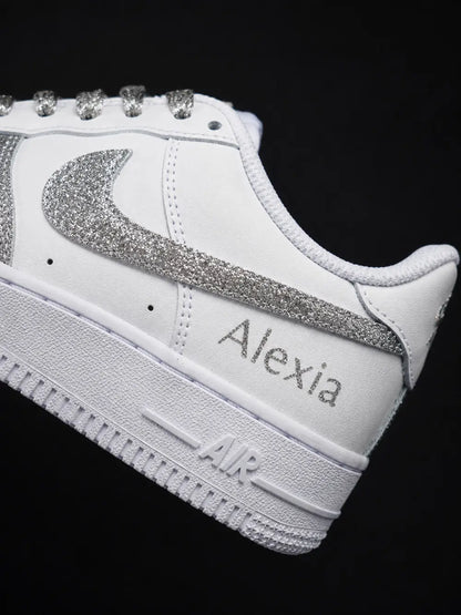 Détail du swoosh glitter argent sur une Nike Air Force 1 personnalisée blanche avec finition pailletée artisanale haut de gamme.