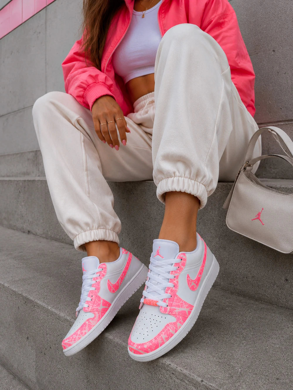 Air Jordan Low rose personnalisée portée avec une tenue streetwear féminine tendance.