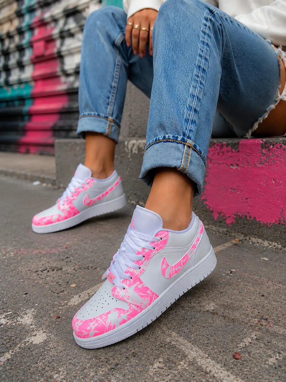 Air Jordan Low custom pink splash pour femme avec finitions artisanales et style streetwear premium.