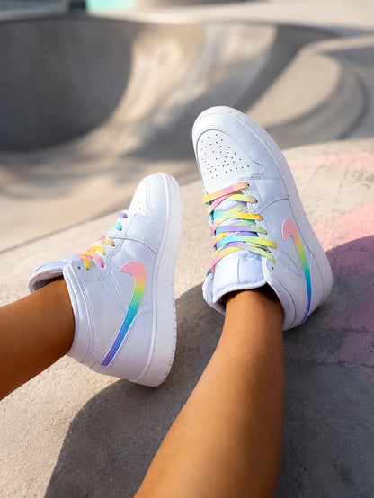 Air Jordan Mid personnalisée pastel portée en extérieur, basket custom femme aux finitions arc-en-ciel.