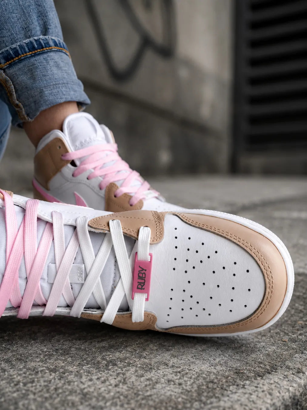Détail d'une Jordan Mid rose personnalisée avec bijou lacet prénom et finition artisanale.