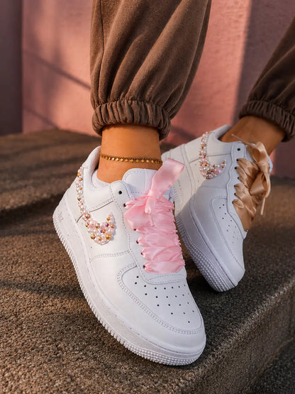 Basket Nike Air Force 1 custom femme avec swoosh perlé rose gold et lacets satin élégants pour tenue streetwear tendance