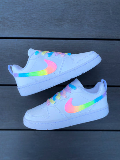 Sur la photo, des baskets Nike au design vibrant, mélangeant plusieurs couleurs fluo pour un effet arc-en-ciel.