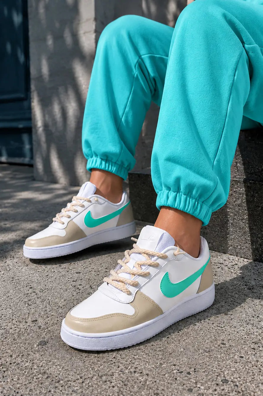 Nike personnalisées beige et turquoise portées en look streetwear féminin, baskets custom tendance avec swoosh turquoise pastel.