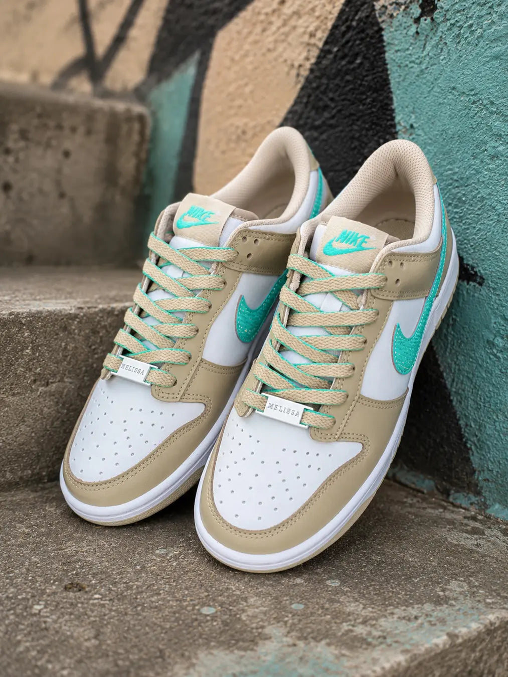 Vue arrière d'une Nike Dunk Low personnalisée beige sable avec personnalisation du prénom et détails turquoise.
