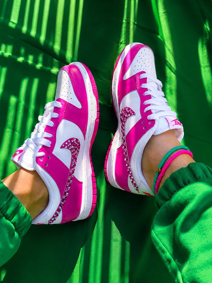 Basket Nike Dunk Low custom femme rose fuchsia avec strass, portée en extérieur style streetwear.