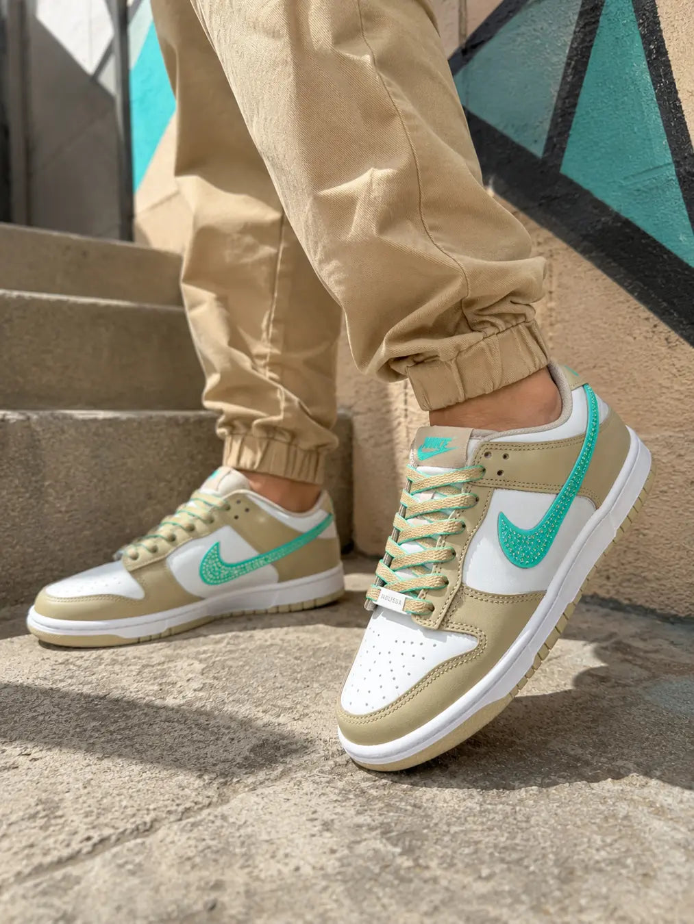 Basket Nike personnalisée beige sable portée avec finition artisanale et personnalisation turquoise.