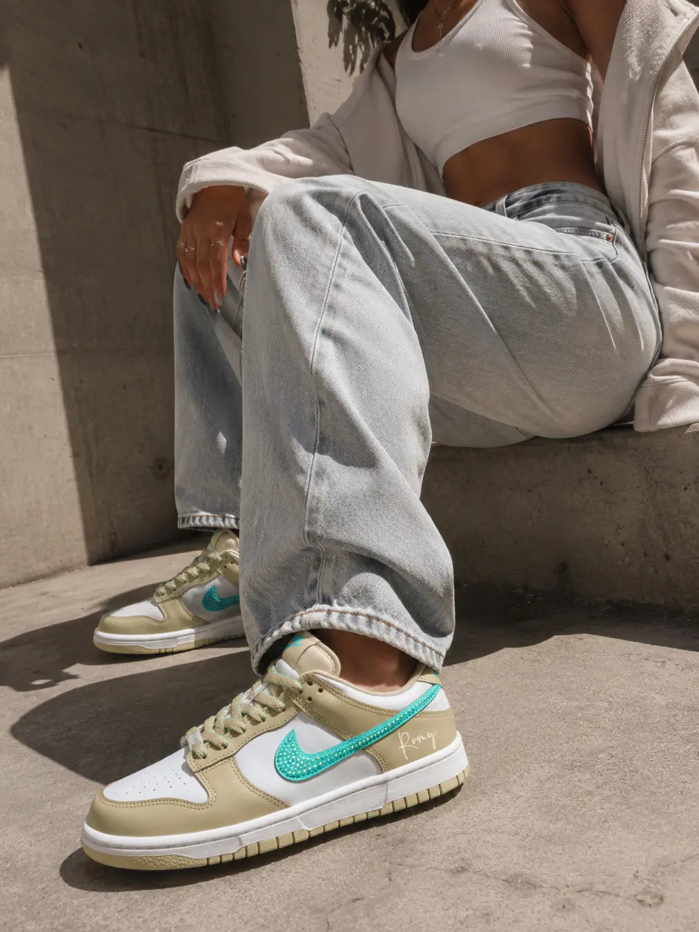Nike Dunk Low personnalisée beige sable avec prénom personnalisé et swoosh turquoise pailleté.