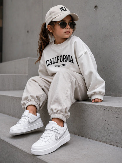 Baskets Nike personnalisées pour enfant dans un style streetwear premium avec finition blanche et personnalisation artisanale.