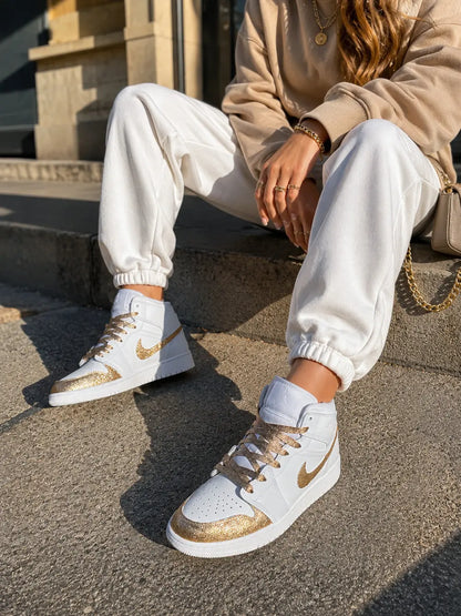 Nike Air Jordan 1 Mid personnalisée avec prénom doré au talon et détails glitter gold sur cuir blanc