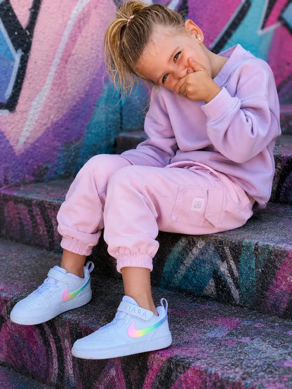 Basket personnalisée Nike pastel pour fille portée avec une tenue streetwear enfant moderne et tendance.