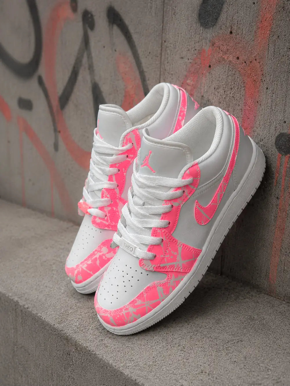 Paire de Air Jordan Low personnalisées rose fluo avec design exclusif pour femme.