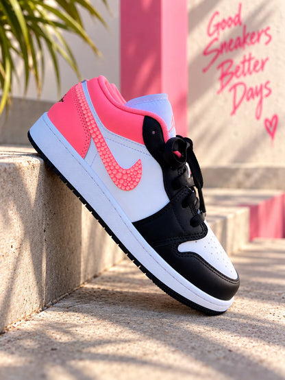 Air Jordan Low custom femme avec Swoosh rose corai en relief, finition rose fluo et design streetwear noir et blanc