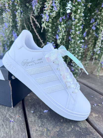 Sneakers de mariée Adidas blanches avec bandes pailletées et lacets irisés pour cérémonie de mariage.