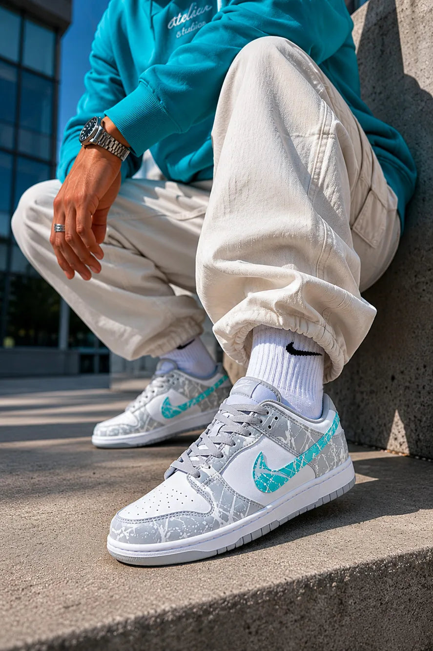 Nike Dunk personnalisée gris et turquoise associée à une tenue streetwear contemporaine, création premium.